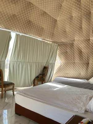 a bedroom with two beds and a mosquito net at Wadi rum camp in Wadi Rum
