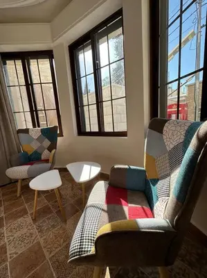 a living room with a couch and chairs and windows at 1/ Antica jabalal-lwebdeh in Amman