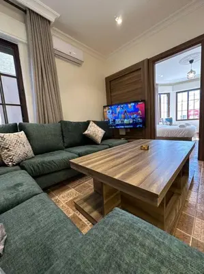 a living room with a green couch and a wooden table at 1/ Antica jabalal-lwebdeh in Amman