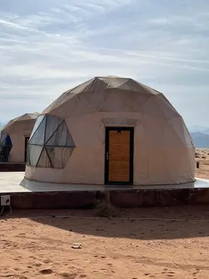 two large domed tents in the desert with a door at Madonna Rum camp bubbles & Jeep tours in Wadi Rum