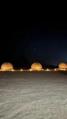 three domes in the middle of a field at night at Madonna Rum camp bubbles & Jeep tours in Wadi Rum