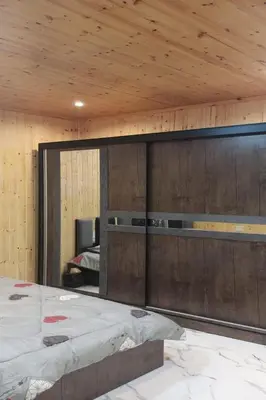 a bedroom with a large bed and a wooden ceiling at white tulips studio in Jerash