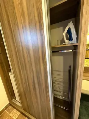 a closet with a wooden door and a refrigerator at 2/ Antica jabalal-lwebdeh in Amman
