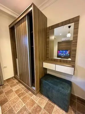 a bathroom with a television and a blue ottoman at 2/ Antica jabalal-lwebdeh in Amman