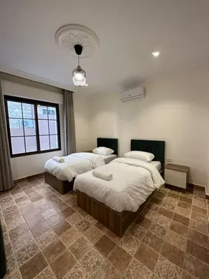 a bedroom with two beds and a large window at 3/ Antica jabalal-lwebdeh in Amman