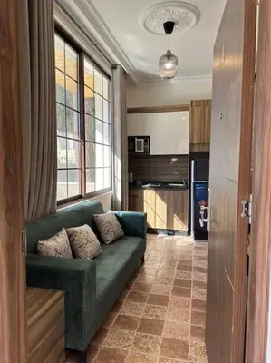 a living room with a green couch in a kitchen at 4/ Antica jabalal-lwebdeh in Amman