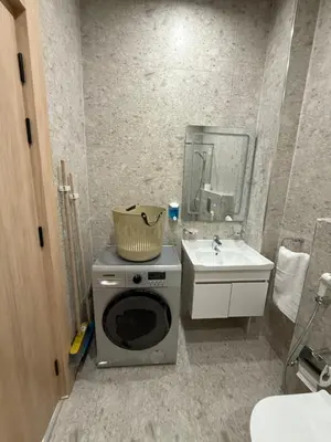 a small bathroom with a washing machine and a sink at Karak Plaza Residences in Kerak