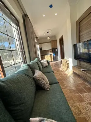 a living room with a couch and a television at 5/ Antica jabalal-lwebdeh in Amman