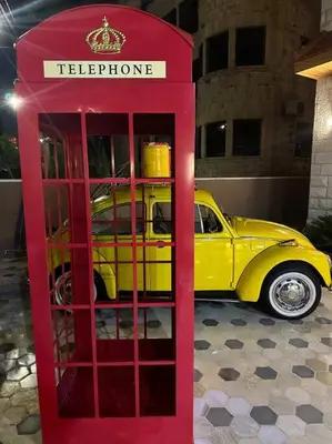 a red phone booth in front of a yellow car at 8/ Antica jabalal-lwebdeh in Amman