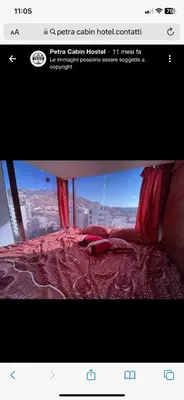 a picture of a bed with a view of a city at Petra inbox Hostel in Wadi Musa