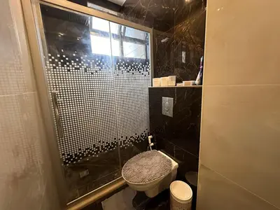 a bathroom with a toilet and a glass shower at Luxury Abdoun apartment in Amman