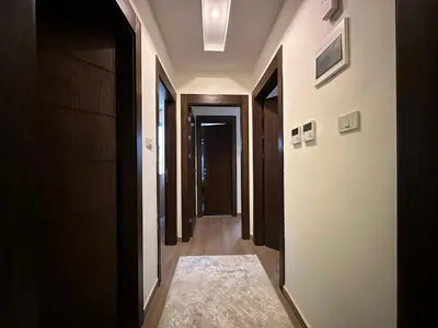 a hallway with several doors and a rug on the floor at Luxury Abdoun apartment in Amman