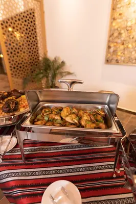 a buffet with a tray of chicken and other food at Valley Resort in Wadi Rum