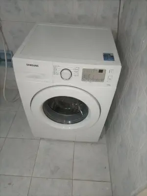 a white washing machine sitting in a bathroom at Decapolis with garden in Irbid