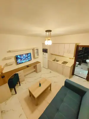 a living room with a blue couch and a table at Royal Luxury Amman Central Apartments in Amman
