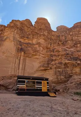 a bus parked in the desert near a mountain at Luxury tent camp in Wadi Rum