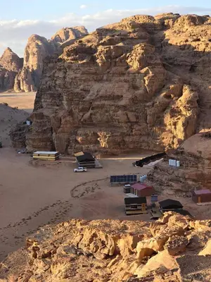 an aerial view of a desert with a mountain at Luxury tent camp in Wadi Rum