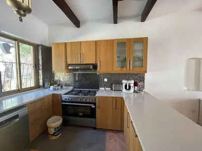 a kitchen with wooden cabinets and a stove top oven at Horizon Villa in Amman