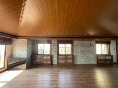 an empty room with a wooden ceiling and windows at Horizon Villa in Amman