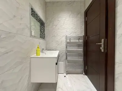 a white bathroom with a sink and a mirror at Horizon Villa in Amman