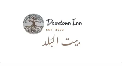 a logo for a mushroom inn with a tree at Downtown Inn Madaba in Madaba