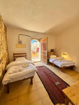 a room with three beds and a window at Dana Tower Hotel in Dana