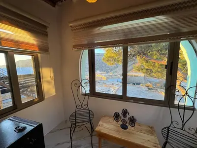 a room with windows and a wooden table and chairs at Dana Tower Hotel in Dana