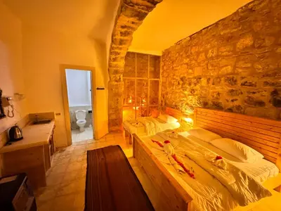 a bedroom with two beds and a stone wall at Dana Tower Hotel in Dana