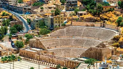 an ancient amphitheater in a city with buildings at Conord Hotel in Amman