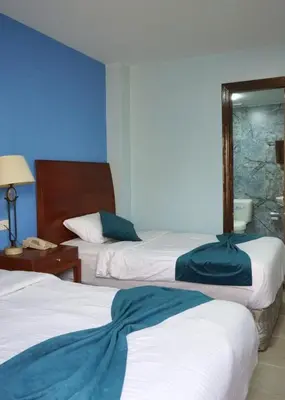 a hotel room with two beds and a mirror at Conord Hotel in Amman