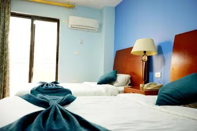 a hotel room with two beds with blue walls at Conord Hotel in Amman