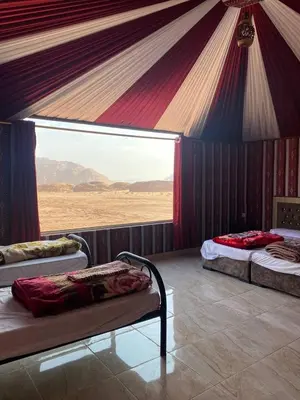 a room with three beds in a tent at Lucas Camp Wadi Rum in Wadi Rum