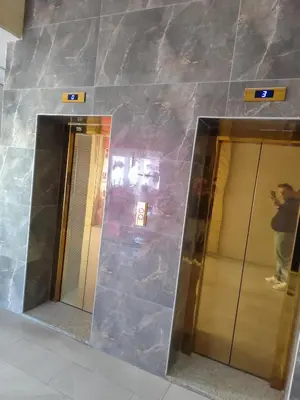 a person taking a picture of two elevators in a building at Gentle Breeze Studio 1 in Amman