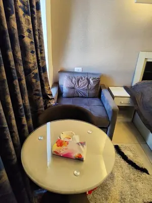 a living room with a table and a couch at Gentle Breeze Studio 1 in Amman