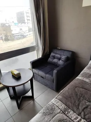 a room with a couch and a table and a window at Gentle Breeze Studio 1 in Amman