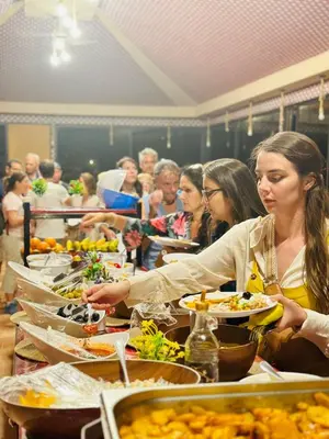 a group of people sitting at a table eating food at Dessert flowers wadi rum in Disah