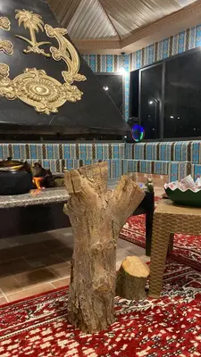 a tree stump sitting in a room with a table at Dessert flowers wadi rum in Disah