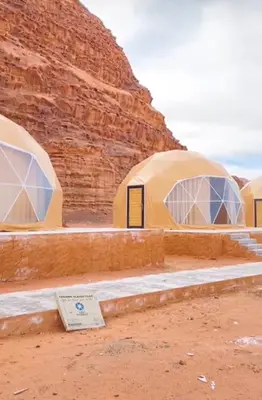 a group of three dome tents in a desert at Dessert flowers wadi rum in Disah