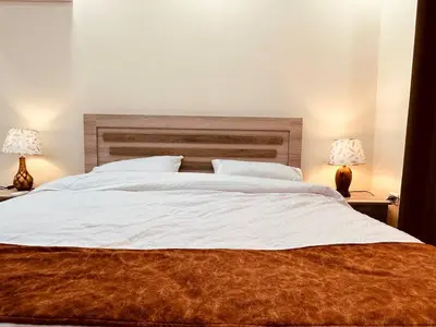 a bedroom with a large white bed with two lamps at Dream Hotel jerash in Jerash