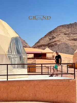 a man riding a skateboard in front of a tent at WADI RuM GRAND in Wadi Rum