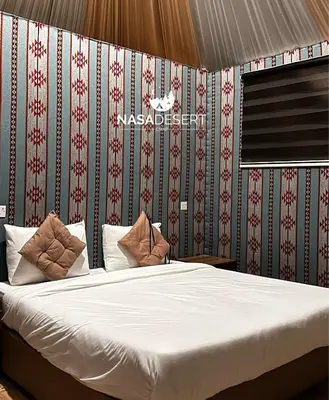 a bedroom with a large bed with red and green wallpaper at Nasa desert luxury camp in Wadi Rum