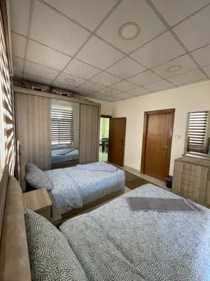 a bedroom with two beds and a couch at Apartment for rent 50M fully furnished - in Amman