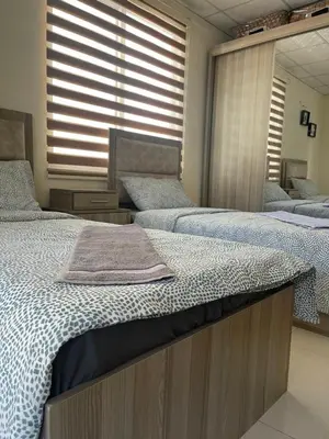 a bedroom with two beds and a mirror at Apartment for rent 50M fully furnished - in Amman