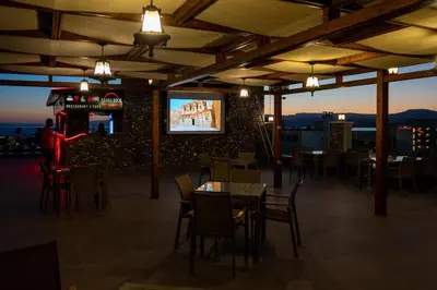 a restaurant with tables and chairs and a television on a wall at My Hotel by Trend in Aqaba
