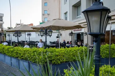 a street light with people sitting at tables under umbrellas at My Hotel by Trend in Aqaba