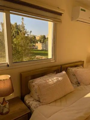 a bedroom with two beds and a large window at Classy Guesthouse in Madaba