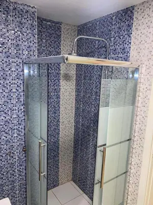 a shower in a bathroom with blue tiles at The view in Amman