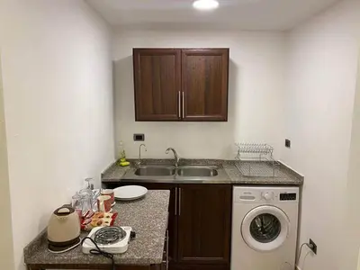 a kitchen with a sink and a washing machine at The view in Amman