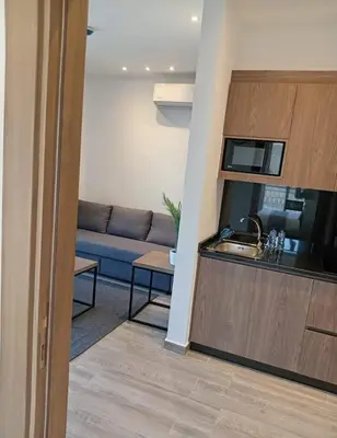 a living room with a couch and a kitchen at Alshakreen suites in Amman