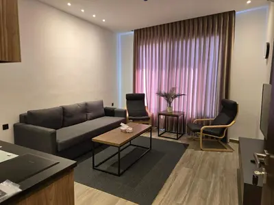 a living room with a couch and a table and chairs at Alshakreen suites in Amman